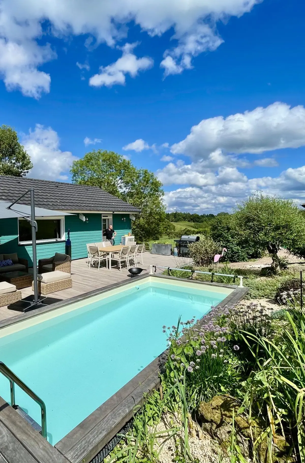 La piscine qui longe le Chalet Normand et sa terrasse de bois