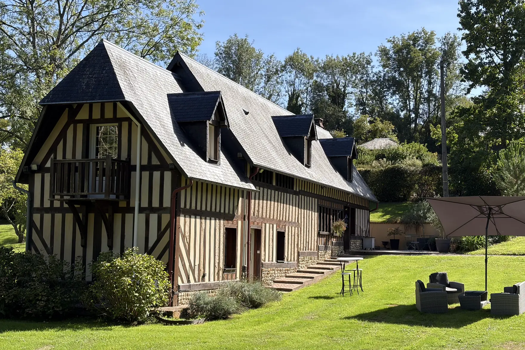 Reinette Grise, sa façade à colombages et son toit d’ardoise, au bord de la pelouse