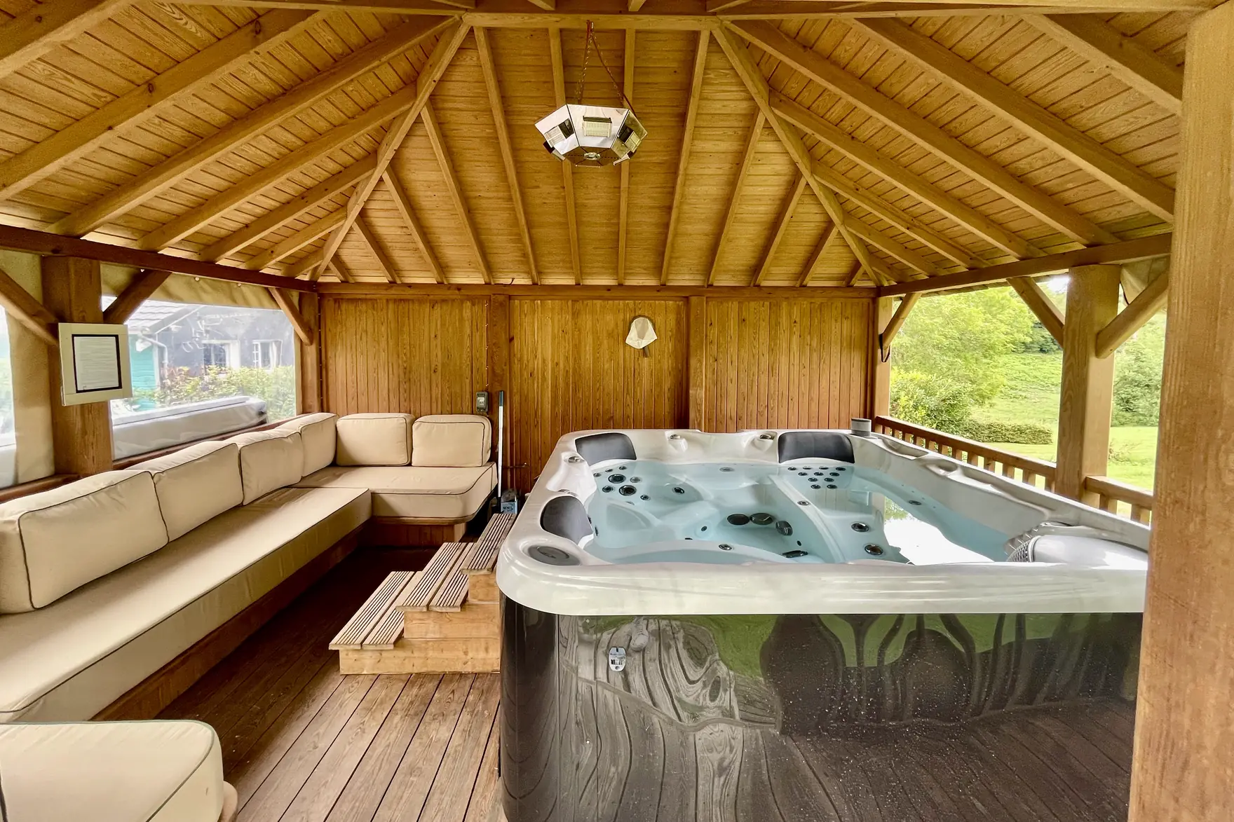 Le jacuzzi sous le kiosque de bois, ouvert sur les prés